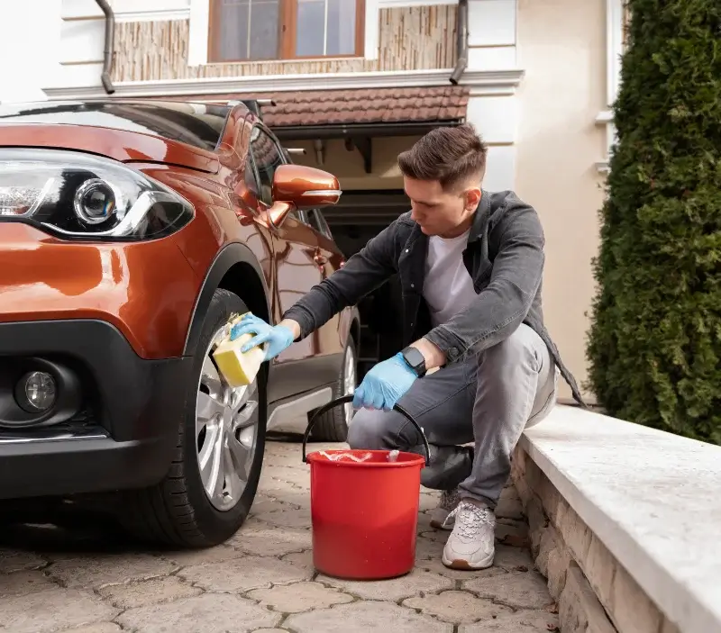Lavage auto à domicile Lasséran : professionnel intervenant sur un véhicule